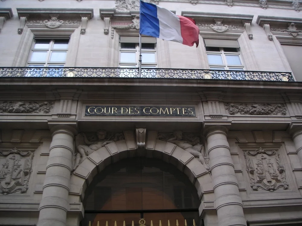 Façade du bâtiment de la Cour des comptes française avec drapeau tricolore et inscription sur fronton.