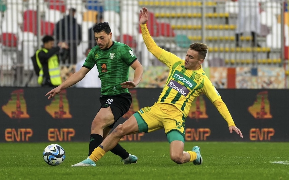 Match de football de Ligue 1 algérienne entre le CS Constantine (maillot vert et noir) et la JS Kabylie (maillot jaune et vert) en mars 2025. Deux joueurs se disputent le ballon au sol.