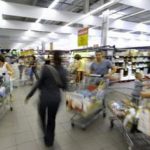 Client poussant un chariot dans les rayons d'un supermarché
