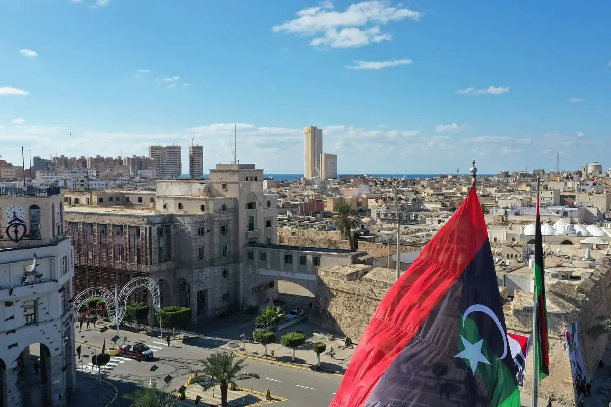 Vue aérienne de Tripoli avec le drapeau libyen au premier plan.