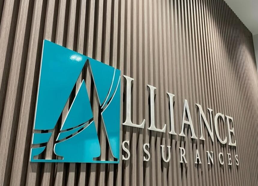 Logo Alliance Assurances en lettres relief sur fond de boiseries, siège social de la compagnie.