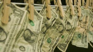 Billets de dollars suspendus à une corde avec des pinces à linge, illustration du blanchiment d'argent et de la liste grise du GAFI.