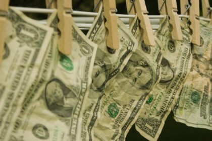 Billets de dollars suspendus à une corde avec des pinces à linge, illustration du blanchiment d'argent et de la liste grise du GAFI.