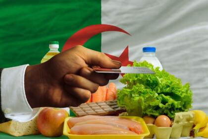 Courses alimentaires devant un drapeau algérien — inflation et pouvoir d'achat en Algérie