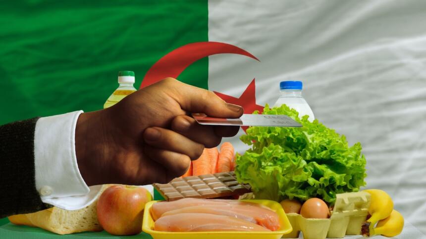 Courses alimentaires devant un drapeau algérien — inflation et pouvoir d'achat en Algérie