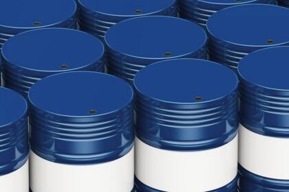 Rangées de barils de pétrole bleus et blancs empilés, représentant les stocks mondiaux de brut