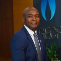 Philip Mshelbila, secrétaire général du GECF, costume bleu marine, devant le logo du Forum