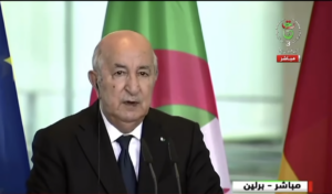 Capture d'écran de la télévision algérienne montrant Abdelmadjid Tebboune s'exprimant au pupitre lors de la conférence de presse avec Friedrich Merz à Berlin, devant les drapeaux algérien et européen