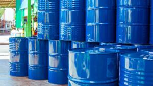Fûts métalliques bleus empilés sur une aire de stockage industrielle