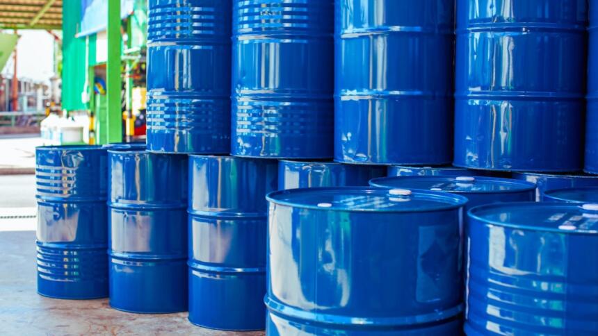 Fûts métalliques bleus empilés sur une aire de stockage industrielle