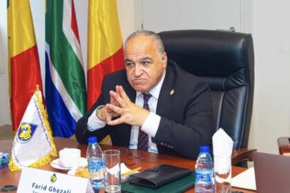 Farid Ghezali, secrétaire général de l'Organisation africaine des producteurs de pétrole, assis à son bureau devant les drapeaux des pays membres, au siège de l'APPO à Brazzaville.