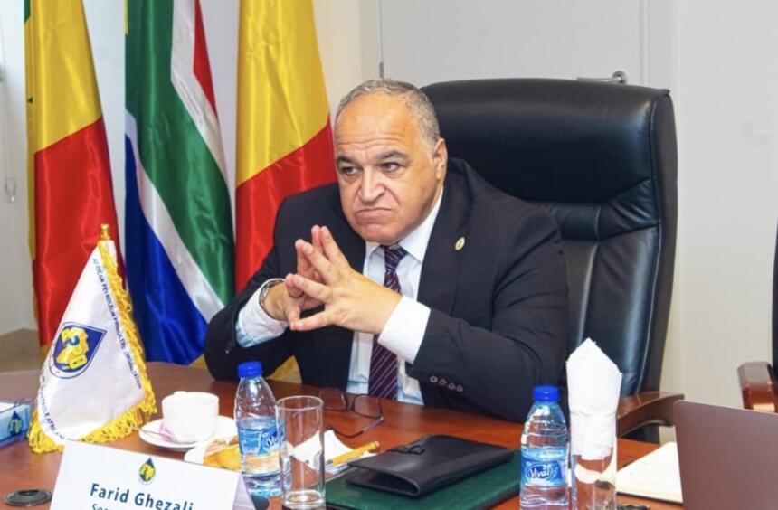Farid Ghezali, secrétaire général de l'Organisation africaine des producteurs de pétrole, assis à son bureau devant les drapeaux des pays membres, au siège de l'APPO à Brazzaville.