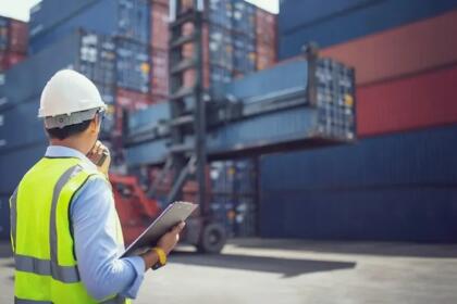 Agent portuaire vérifiant un dossier d'exportation devant des conteneurs