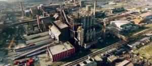 Vue aérienne du complexe sidérurgique d'El Hadjar à Annaba, avec haut-fourneau, cheminées industrielles et voies ferrées.