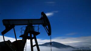 Pompe à pétrole (derrick) silhouettée la nuit sous un ciel étoilé