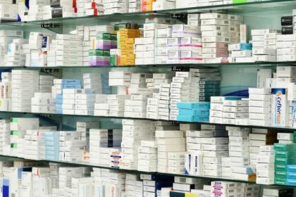 Rayonnages d'une pharmacie remplis de boîtes de médicaments, illustrant le secteur pharmaceutique concerné par la prolongation du PPI décidée par l'ABEF.