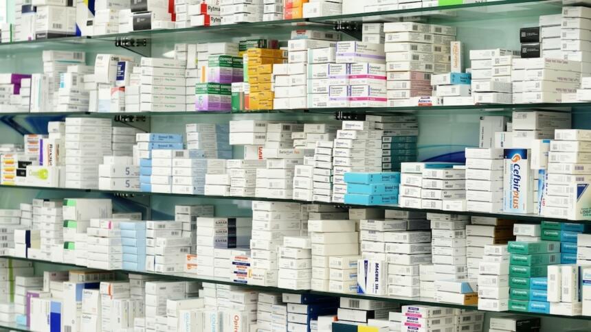 Rayonnages d'une pharmacie remplis de boîtes de médicaments, illustrant le secteur pharmaceutique concerné par la prolongation du PPI décidée par l'ABEF.