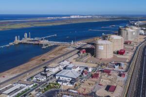 Vue aérienne du terminal de regazéification de gaz naturel liquéfié d'Enagás en Espagne, avec ses cuves de stockage et son quai portuaire.