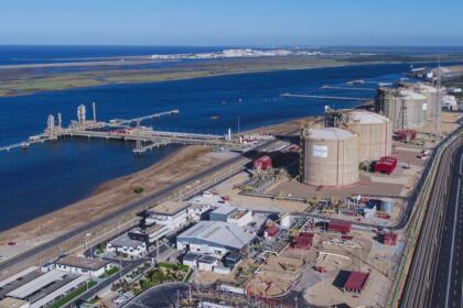 Vue aérienne du terminal de regazéification de gaz naturel liquéfié d'Enagás en Espagne, avec ses cuves de stockage et son quai portuaire.
