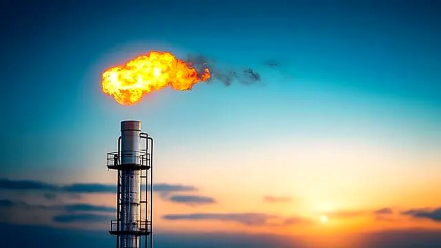 torchère de gaz en combustion sur un site pétrolier au coucher du soleil