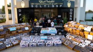Cartons et bacs de comprimés et de plaquettes de drogue disposés au sol devant le siège du Service central de lutte contre le trafic illicite de stupéfiants, à Alger.