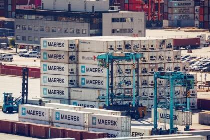 Empilements de conteneurs Maersk et cavaliers gerbeurs sur un terminal portuaire