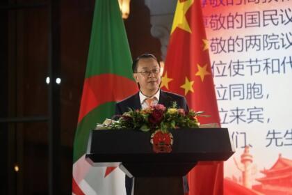 Dong Guangli, ambassadeur de Chine en Algérie, prononce un discours à un pupitre devant les drapeaux algérien et chinois, lors de la réception du 77e anniversaire de la fondation de la République populaire de Chine à Alger
