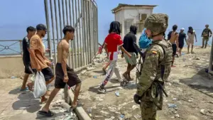 Ceuta, des jeunes marocains quittent l'enclave sous le regard d'un soldat espagnol (dr)