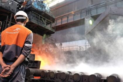 Ouvrier d'ArcelorMittal observant une coulée d'acier en fusion au complexe sidérurgique d'El Hadjar