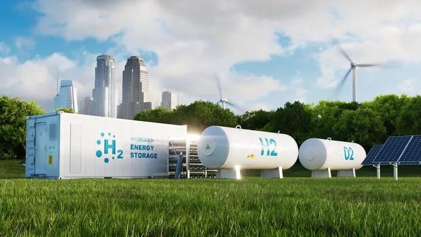 Rendu 3D d'un conteneur blanc marqué « H2 Hydrogen Energy Storage » et de deux réservoirs cylindriques blancs posés sur une pelouse, avec des éoliennes, un panneau solaire et des gratte-ciel en arrière-plan.