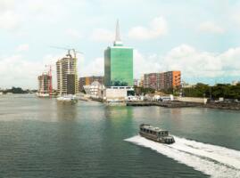 Vue depuis un bateau-taxi sur la lagune de Lagos, avec les gratte-ciel du Civic Centre Towers et des tours en construction en arrière-plan, illustrant le développement urbain de l'un des pôles économiques d'Afrique