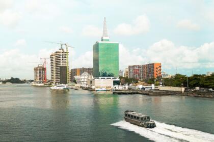 Vue depuis un bateau-taxi sur la lagune de Lagos, avec les gratte-ciel du Civic Centre Towers et des tours en construction en arrière-plan, illustrant le développement urbain de l'un des pôles économiques d'Afrique