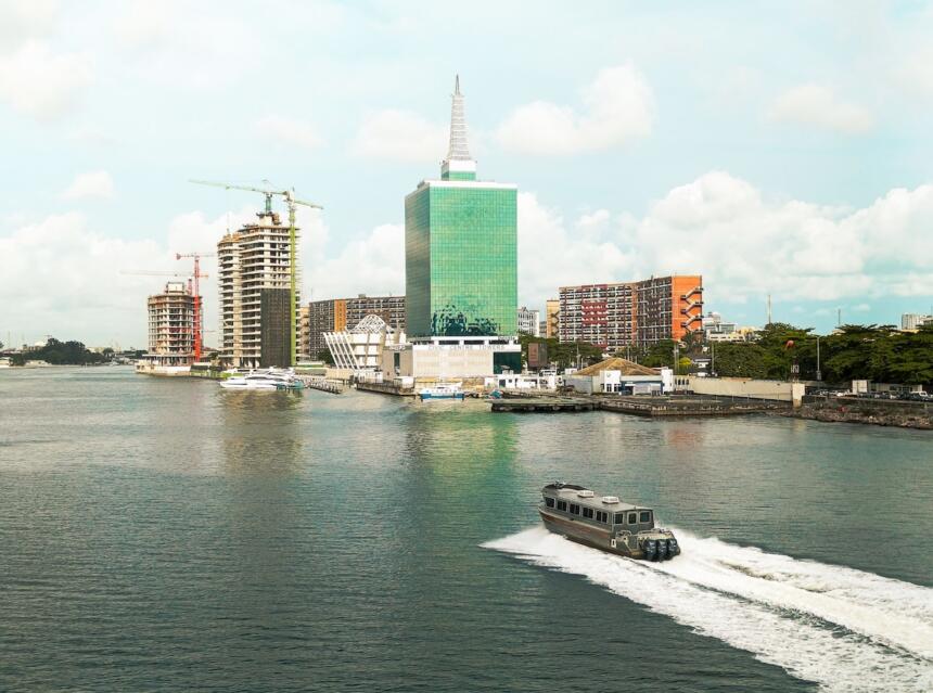 Vue depuis un bateau-taxi sur la lagune de Lagos, avec les gratte-ciel du Civic Centre Towers et des tours en construction en arrière-plan, illustrant le développement urbain de l'un des pôles économiques d'Afrique