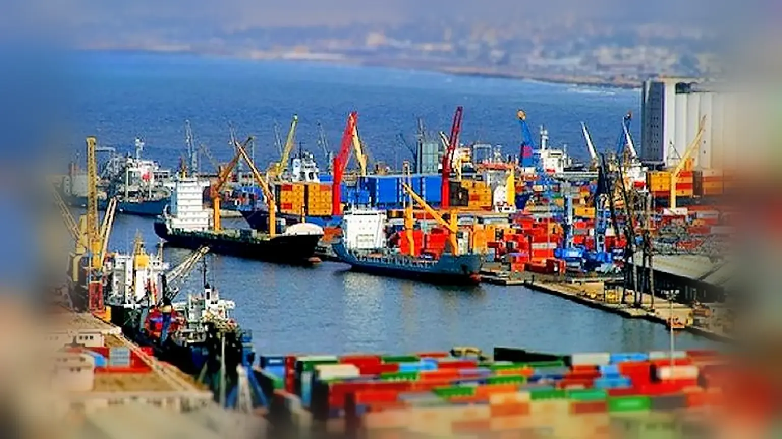 Porte-conteneurs et grues à quai dans un port algérien, avec des piles de conteneurs au premier plan.