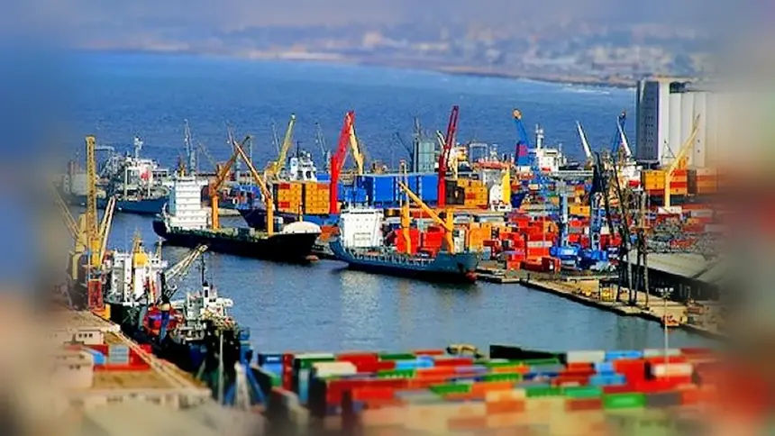 Porte-conteneurs et grues à quai dans un port algérien, avec des piles de conteneurs au premier plan.