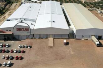 Usine du groupe Vicky Foods portant le logo Dulcesol, bâtiment industriel avec parking et camions de livraison