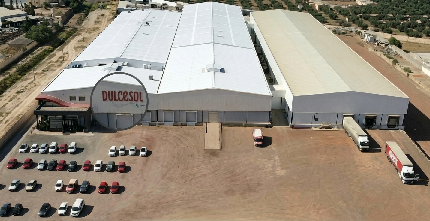 Usine du groupe Vicky Foods portant le logo Dulcesol, bâtiment industriel avec parking et camions de livraison