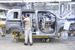 Ouvriers assemblant la carrosserie d'un véhicule Fiat sur la chaîne de l'usine de Tafraoui, à Oran