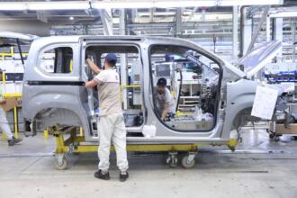 Ouvriers assemblant la carrosserie d'un véhicule Fiat sur la chaîne de l'usine de Tafraoui, à Oran