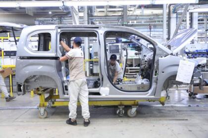 Ouvriers assemblant la carrosserie d'un véhicule Fiat sur la chaîne de l'usine de Tafraoui, à Oran