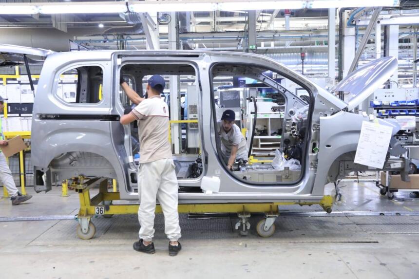 Ouvriers assemblant la carrosserie d'un véhicule Fiat sur la chaîne de l'usine de Tafraoui, à Oran