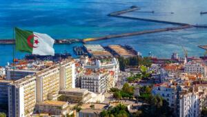 Vue aérienne du port d’Alger, avec ses jetées, ses navires à quai et les immeubles blancs du front de mer.
