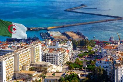 Vue aérienne du port d’Alger, avec ses jetées, ses navires à quai et les immeubles blancs du front de mer.