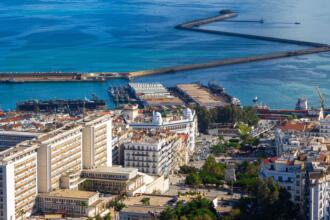 Vue aérienne du port d'Alger, avec ses jetées, des navires à quai et les immeubles du front de mer