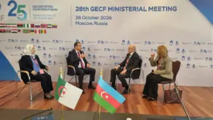 Quatre personnes en entretien devant le panneau de la 28e réunion ministérielle du GECF à Moscou, avec les drapeaux de l’Algérie et de l’Azerbaïdjan sur la table.
