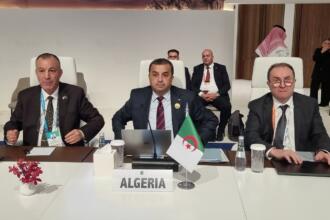 Trois membres de la délégation algérienne assis derrière la plaque « Algeria » au WPC Energy 2026, à Riyad