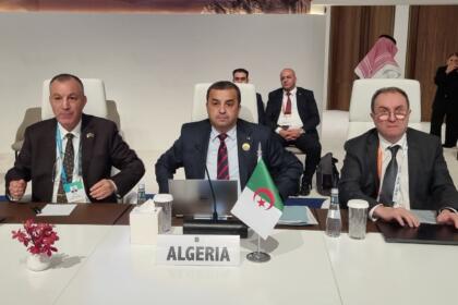Trois membres de la délégation algérienne assis derrière la plaque « Algeria » au WPC Energy 2026, à Riyad