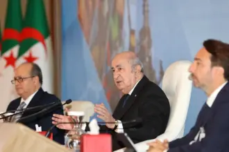 Abdelmadjid Tebboune s'exprimant à la tribune, entouré de Kamel Moula, président du CREA, et du Premier ministre Sifi Ghrieb, à Alger.