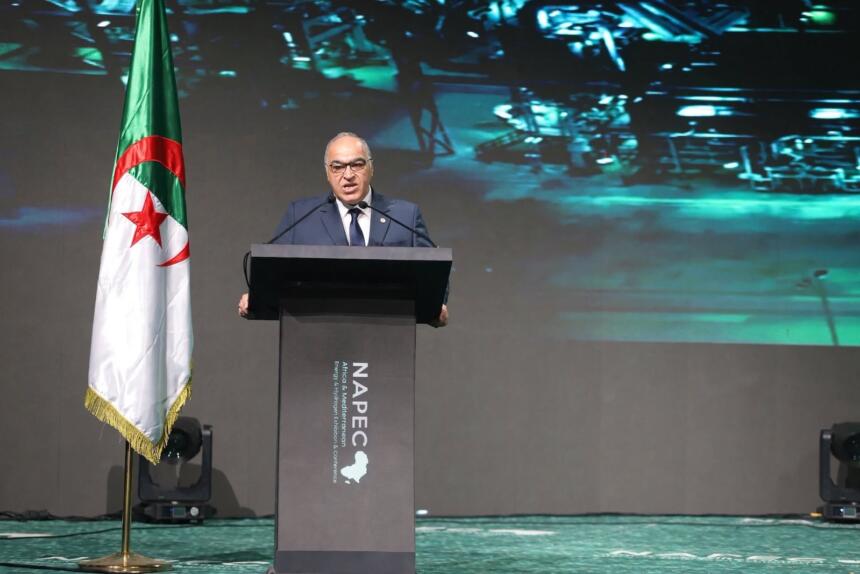 Farid Ghezali, secrétaire général de l'APPO, au pupitre du NAPEC 2026 à Oran, à côté d'un drapeau algérien