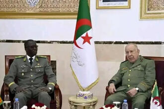 Le général d’armée Saïd Chanegriha et le ministre nigérien de la Défense nationale assis côte à côte dans des fauteuils, de part et d’autre d’un drapeau algérien.